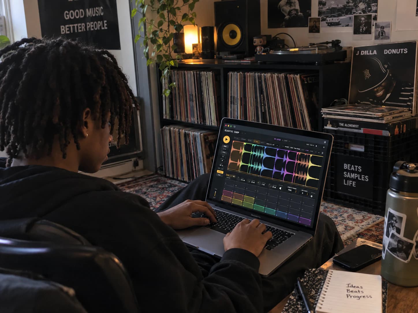 A producer chopping a break in Elastic Chop on a laptop, surrounded by records